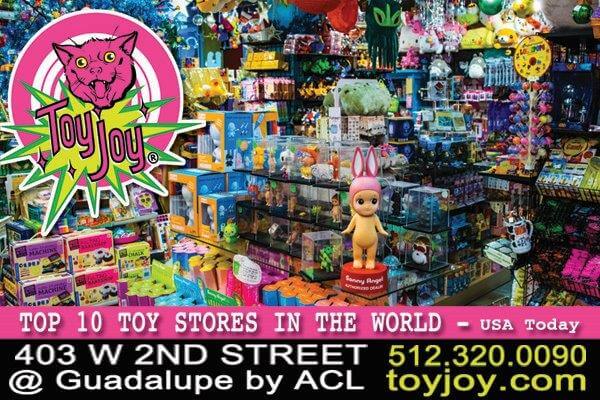 A toy store with lots of toys and a pink doll.